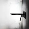 Schwarzer Wasserhahn vor Betonwand im modernen Design
